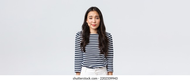 Lifestyle, people emotions and casual concept. Shy and modest cute clueless girl, smirk and looking camera uncertain, having doubts or hesitations, standing white background
