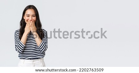 Lifestyle, people emotions and casual concept. Cute silly asian female giggle while gossiping and mocking someone, cover mouth as smiling and laughing carefree Сток-фото © 