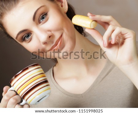 lifestyle, people and food concept: young woman with coffee and cookies