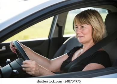 Lifestyle Photo Of Attractive Mature Woman Driving Car