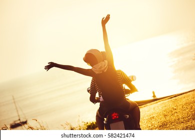 Lifestyle photo of happy couple on motorcycle traveling to the sea at sunset time - Powered by Shutterstock