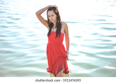 lifestyle photo of woman with perfect hair.walking alone at the beach.Sensual young girl relaxing.Colorful filter.glam style,teen trend outfit, positive mood,smiling,amazing model girl,long hair