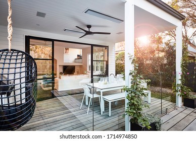Lifestyle photography of an outdoor poolside patio area in a stylish modern coastal style home, shot late afternoon