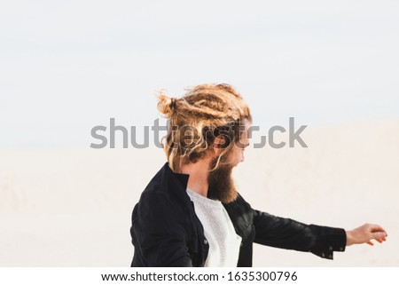 Lifestyle Photography. A young blonde handsome man outdoors in the beach in a sunny day