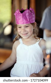 Lifestyle Photography Of A Young Girl Wearing A Paper Hat From A Christmas Cracker