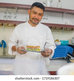 Lifestyle Portrait Of Asian Home Cook Man Or Professional Chef Cooking In Clean Kitchen Showing Traditional Japanese Sushi Roll Dish Happy And Proud In Japan Food Culture