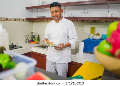 Lifestyle Portrait Of Asian Home Cook Man Or Professional Chef Cooking In Clean Kitchen Showing Traditional Japanese Sushi Roll Dish Happy And Proud In Japan Food Culture