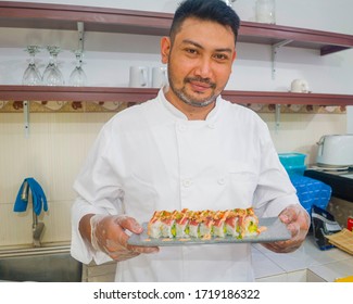 Lifestyle Portrait Of Asian Home Cook Man Or Professional Chef Cooking In Clean Kitchen Showing Traditional Japanese Sushi Roll Dish Happy And Proud In Japan Food Culture