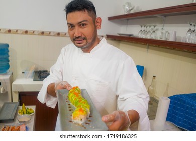 Lifestyle Portrait Of Asian Home Cook Man Or Professional Chef Cooking In Clean Kitchen Showing Traditional Japanese Sushi Roll Dish Happy And Proud In Japan Food Culture