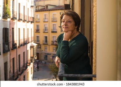 Lifestyle Portrait Of Cheerful Mature And Healthy Woman 60 To 65 Years Old Relaxed On Home Balcony Looking To The Street In Healthy Retirement Concept