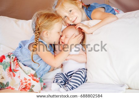 Similar – Baby girl reading book with family in the bed