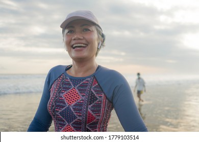 Lifestyle Portrait Of Fit And Happy Middle Aged Woman After Beach Running Workout - 40s Or 50s Attractive Mature Lady With Grey Hair Smiling Cheerful After Jogging Enjoying Fitness