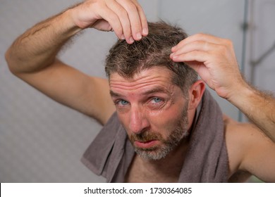 Lifestyle Portrait Of Mid Adult Attractive Concerned And Upset Man At Home Bathroom Searching And Finding Gray Hair Looking At The Mirror Worried About Aging 