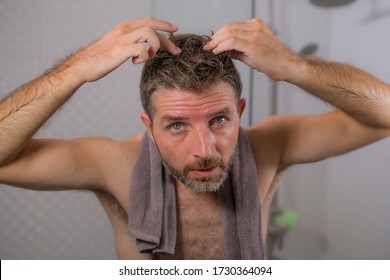 Lifestyle Portrait Of Mid Adult Attractive Concerned And Upset Man At Home Bathroom Searching And Finding Gray Hair Looking At The Mirror Worried About Aging 