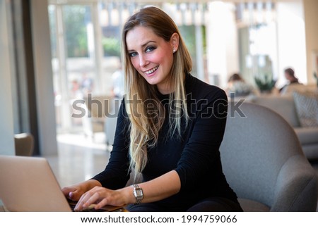 Similar – Entrepreneur woman wearing red shirt working with a laptop sitting on a couch at home