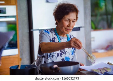 Lifestyle Portrait Of Senior Happy And Sweet Asian Japanese Retired, Woman Cooking At Home Kitchen Alone Neat And Tidy Enjoying Preparing Meal In Elderly And Mature Home Cook Concept