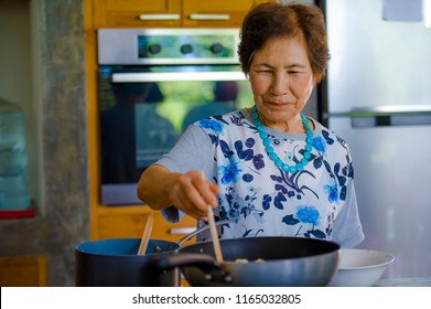 Lifestyle Portrait Of Senior Happy And Sweet Asian Japanese Retired, Woman Cooking At Home Kitchen Alone Neat And Tidy Enjoying Preparing Meal In Elderly And Mature Home Cook Concept