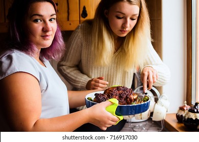 Lifestyle Portrait Of Two Happy Young Women With Baked Turkey For Thanksgiving Dinner, Concept Of Family Eating And Cooking Together