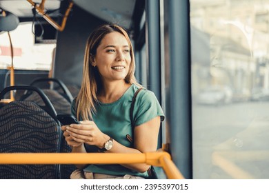 Lifestyle portrait of a young businesswoman sitting with smart phone at the modern train. Woman on a cellphone in public transport. - Powered by Shutterstock