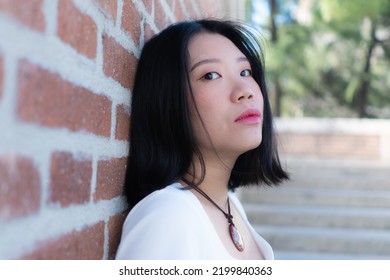 Lifestyle Portrait Of Young Happy And Beautiful Asian Korean Woman Posing Cool Outdoors In City Park