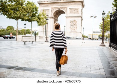 Lifestyle Portrait Of A Young Stylish Business Woman Walking Outdoors Near The Famous Triumphal Arch In Paris