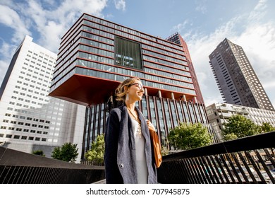 Lifestyle Portrait Of A Young Woman Walking The Bridge At The Modern District With Slyscrapers In Rotterdam City