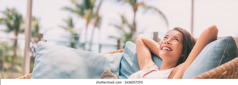 Lifestyle relax happy Asian woman on sofa luxury hotel living banner panoramic. Comfort home summer travel vacation free girl breathing clean air on summer destination panorama.