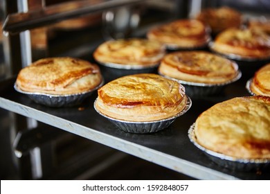 Lifestyle Reportage Photography Of A Pie And Pastry Wholesale Bakery Factory, Finished Meat Pies That Have Finished Baking In Industrial Oven