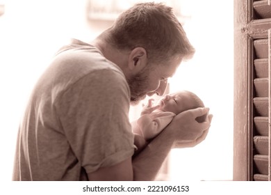 Lifestyle Shot In Black And White Of Young And Happy Man Holding Tenderly In His Arms Adorable Newborn Baby Girl  In Father And Daughter Love And Care Concept