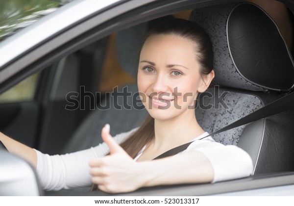 Lifestyle side view portrait of serious lady driver with\
fastened safety seatbelt keeping training, practicing, focusing on\
the driving 
