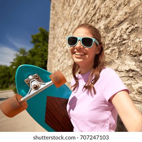 Lifestyle, Summer, Longboarding And People Concept - Smiling Young Woman Or Teenage Girl In Sunglasses With Longboard Taking Selfie Over Stone Wall Outdoors