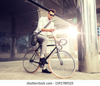 Lebensstil-, Verkehrs-, Kommunikations- und People-Konzept - junger Mann mit Fahrrad und Smartphone auf der Stadtstraße