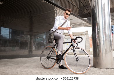 lifestyle, transport, communication and people concept - young man with bicycle and smartphone on city street - Powered by Shutterstock