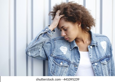 Lifestyle And Trendy Conceptual Photo Of African American Girl Posing In A Silver Metal Wall In A Vintage Denim Jacket . Youth Fashion. Portrait Head Closeup