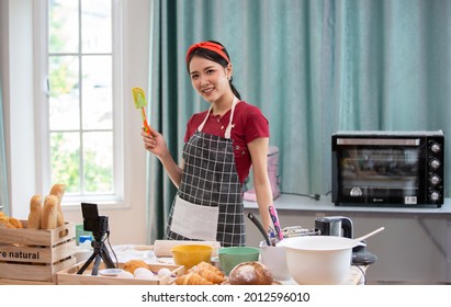 Lifestyle Young asians woman chef wearing apron and baking in home kitchen. Hobby lifestyles concept - Powered by Shutterstock