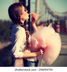 Lifestyle. Young Happy Hipster Woman Eating Sweetened Cotton Candy, Amazing View Of The City From The Bridge. Photo Toned Style Instagram Filters.