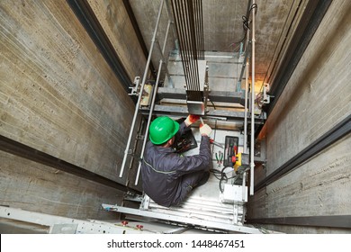 lift machinist repairing elevator in lift shaft - Shutterstock ID 1448467451