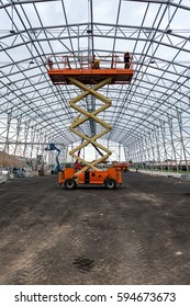 Lift With Platform Work In Warehouse Hangar Construction Field.