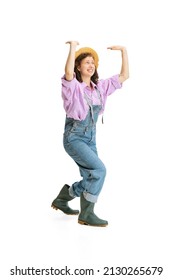 Lift Up. Funny Young Girl, Female Gardener In Work Uniform And Hat Shows Pantomime Isolated On White Background. Concept Of Job, Emotions, Agronomy. Funny Meme Emotions. Copy Space For Ad