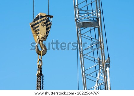 Lifting hook of a construction crane close-up. Blue sky, clean natural background.