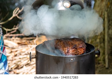 Lifting The Lid To Check On A Large Beef Brisket On A Smoker