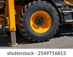 The lifting machine truck crane stands on stops, a large wheel of a tractor                               