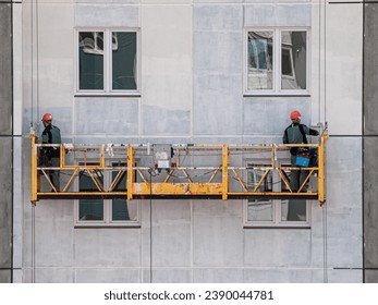 Lifting platform for construction workers working on the facade of a building paint catching seams construction theme close-up
