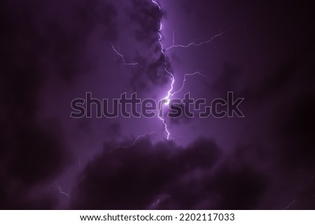 Lighning bolt over night sky in central europe. Huge lightning in a purple clouds at night. Night storm with lightnings