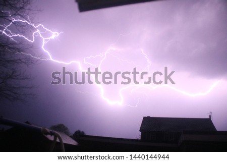 Lighning bolt striking the ground, covering the sky with pure white.