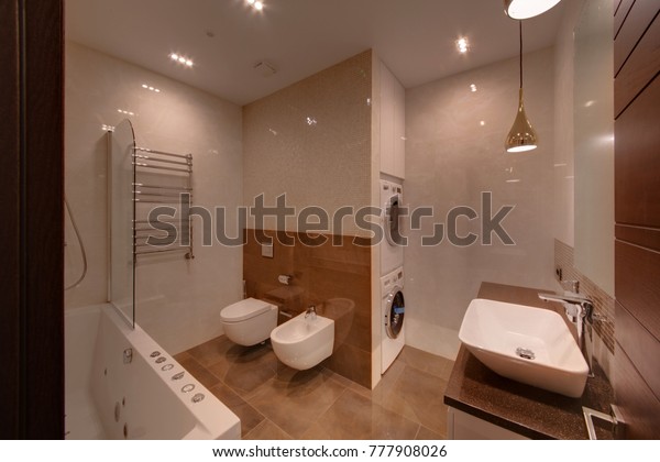 A light bathroom with washing and drying cars and\
light walls
