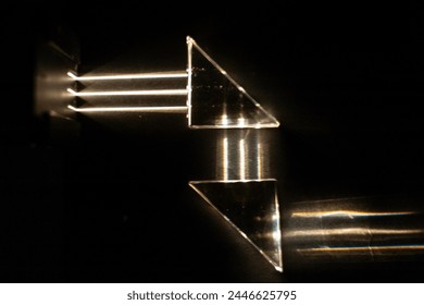 Light beams reflect against mirrored triangles, simulating the operation of a periscope in a submarine. Demonstration test in physics class under dark conditions.