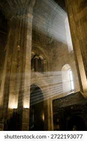 Light Beams Streaming Through Window in Ancient Stone Cathedral Interior