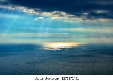 light beams through clouds reflected into the sea. Idyllic and colorful seascape