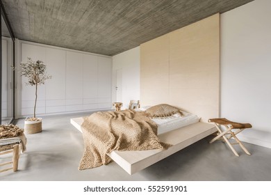 Light bedroom with wooden ceiling and large bed